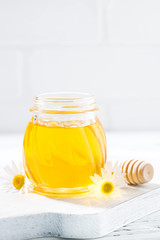 jar of fresh honey on a white background, vertical closeup