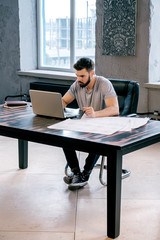 Pensive businessman working on laptop