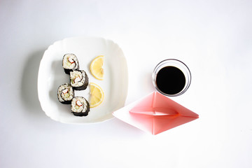 Sushi maki with lemon slices on the white plate