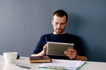 Calm bearded man using tablet