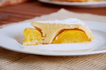 Peach caramel turnover pie sprinkled with sugar powder