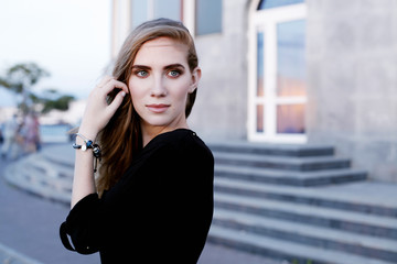 Fototapeta premium Fashionable female model in black blouse and pencil skirt. Spring fashion outfit. 