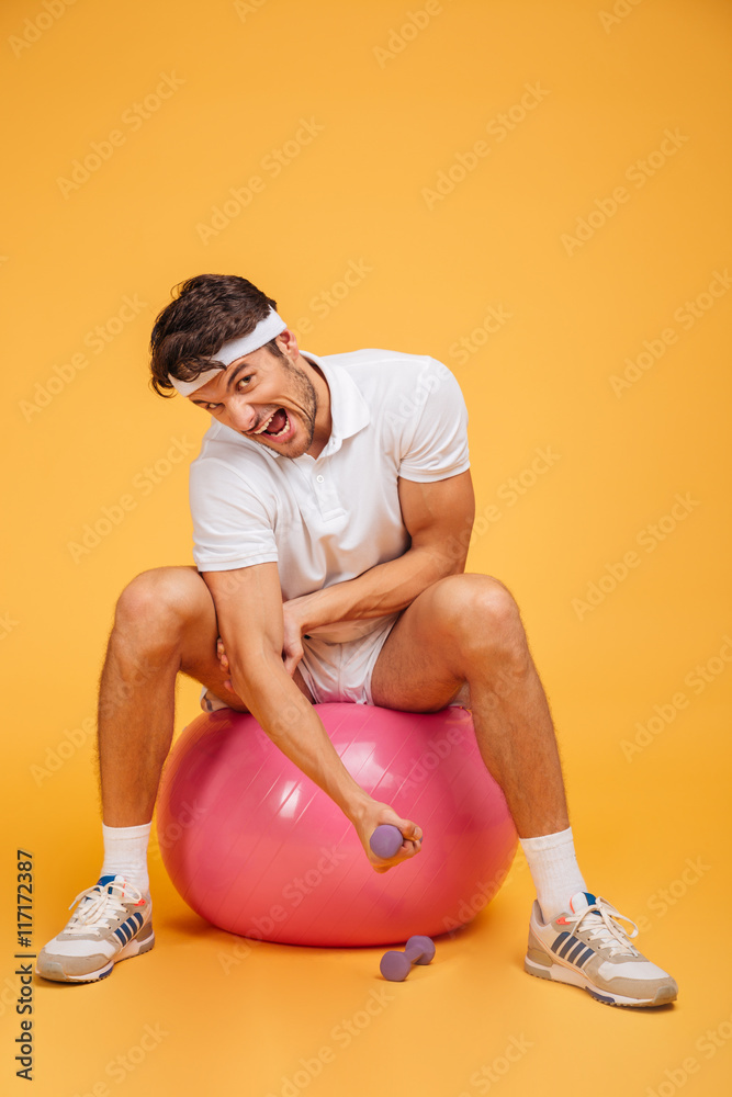 Sticker Sportsman man on fitness ball doing exercises with small dumbbells