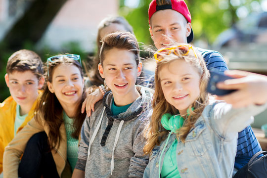 happy teenage students taking selfie by smartphone