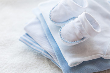 Obraz na płótnie Canvas close up of baby boys clothes for newborn on table