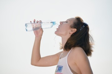 Beautiful young woman drinking water