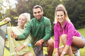Group of friends putting up tent