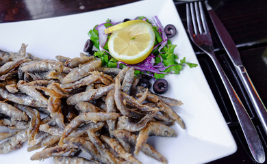 Grilled fish at a restaurant near the beach served on a white pl