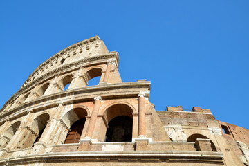 Flavian Amphitheatre or Colosseum in Rome with blue sky in the background, Italy