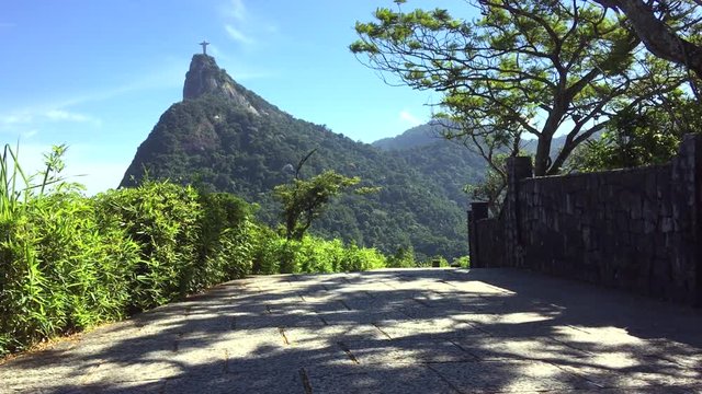 Sun dappled view of the jungle-covered Corcovado Mountain under bright blue skies in Rio de Janeiro, Brazil