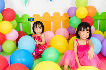 Fototapeta na wymiar Asian Little Chinese Girls Playing with Colorful Balloons