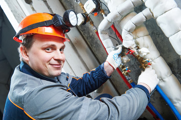 Plumber technician works with water valve
