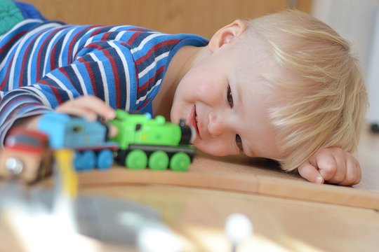 Smiling boy playing with a locomotives