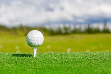 Close up of golf ball and tee with with blurred background.