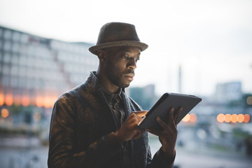 Portrait of young man using digital tablet during sunset