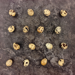Decorative bright pattern with quail eggs on dark stone background