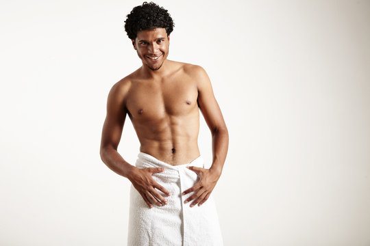 young latin man in white towel is smiling