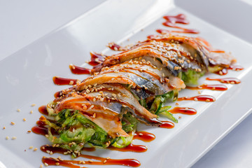Fish snack on a plate with greens