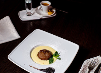 slice of cake on a white plate and cup of coffe on the background
