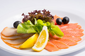 sliced fish on a white plate. Snack from the restaurant menu