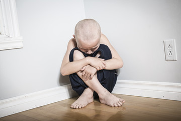 Neglected lonely child leaning at the wall