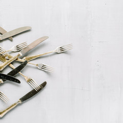 flat lay of golden fork and knife on grey concrete background. top view