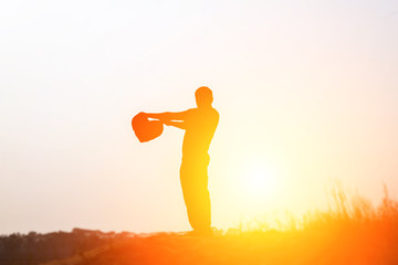 a silhouette of a happy young girl  in front of the sunset in th