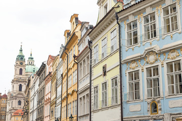 Fototapeta premium Colorful houses in the historic center of Prague. The famous church of St. Nicholas is in the background