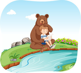 Little boy sitting with bear by the river