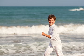 Fototapeta na wymiar Happy boy playing on beach, Spain