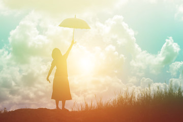 silhouette of woman holding umbrella sunny day