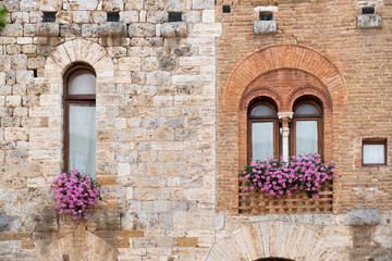 Fototapeta na wymiar Two ancient windows in the medieval truscan town San Gimignano.