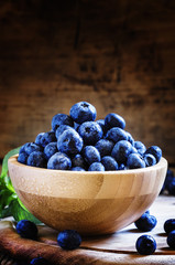 Blueberries in bowl, wooden background, selective focus