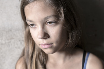 Sad and lonely girl beside wall