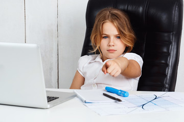 Young beautiful girl pointing finger to camera in office.