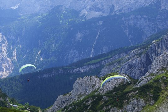 Gleitschirme im Gebirge, von oben fotografiert.