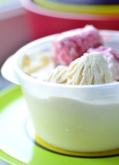Homemade coffee ice cream and ice cream with berry syrup  in a plastic bowl