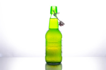Isolated green bottle of beer on a white background lighted from behind