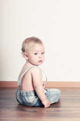 Naklejka premium stressed child sitting on the floor
