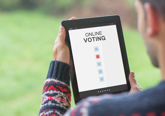 Man voting online with his tablet on a nature atmosphere