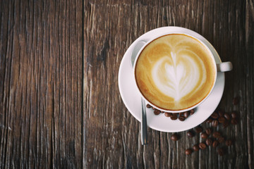 Cup of coffee latte on wood table background, top view