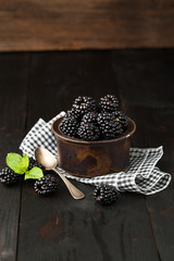 Fototapeta na wymiar Ripe blackberry and mint in a cup