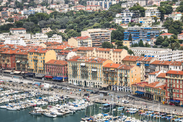 The harbor of Nice in France with some boats, seen from above from behind the cactus trees
