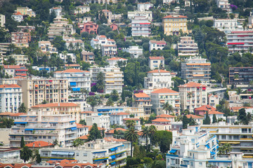 Fototapeta premium Houses in the harbor of Nice in France with some boats, seen from above from behind the cactus trees 