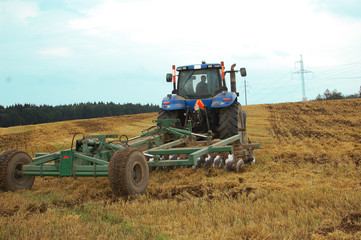 Obraz premium agricultural tractor working on the field in Belarus, Minsk, harvesting