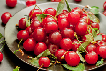 Black plate with delicious, juicy, bright cherries