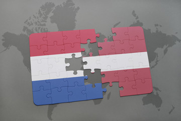 puzzle with the national flag of netherlands and latvia on a world map background.