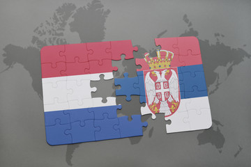 puzzle with the national flag of netherlands and serbia on a world map background.