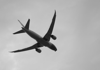 The plane was landing on dark clouds and sky, black and white