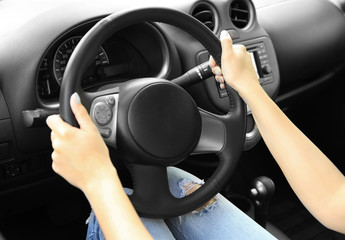 Naklejka premium Female hands on steering wheel